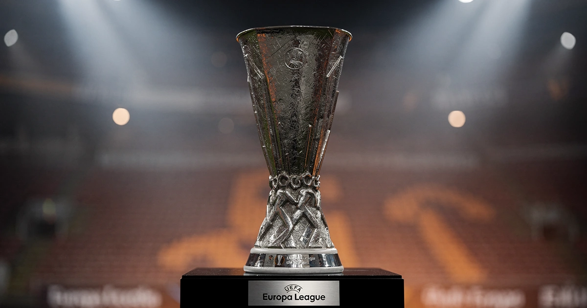 Trofeo de la Europa League sobre pedestal con luces de estadio al fondo